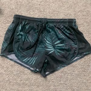 Ardene. Size Medium. Green tropical leaf pattern. Athletic shorts, inner liner.